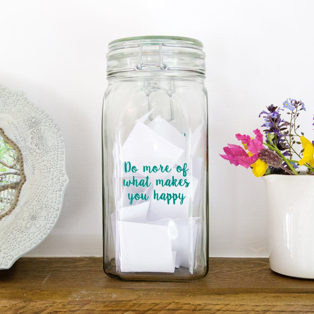 Jar filled with paper notes "Do more of what makes you happy"